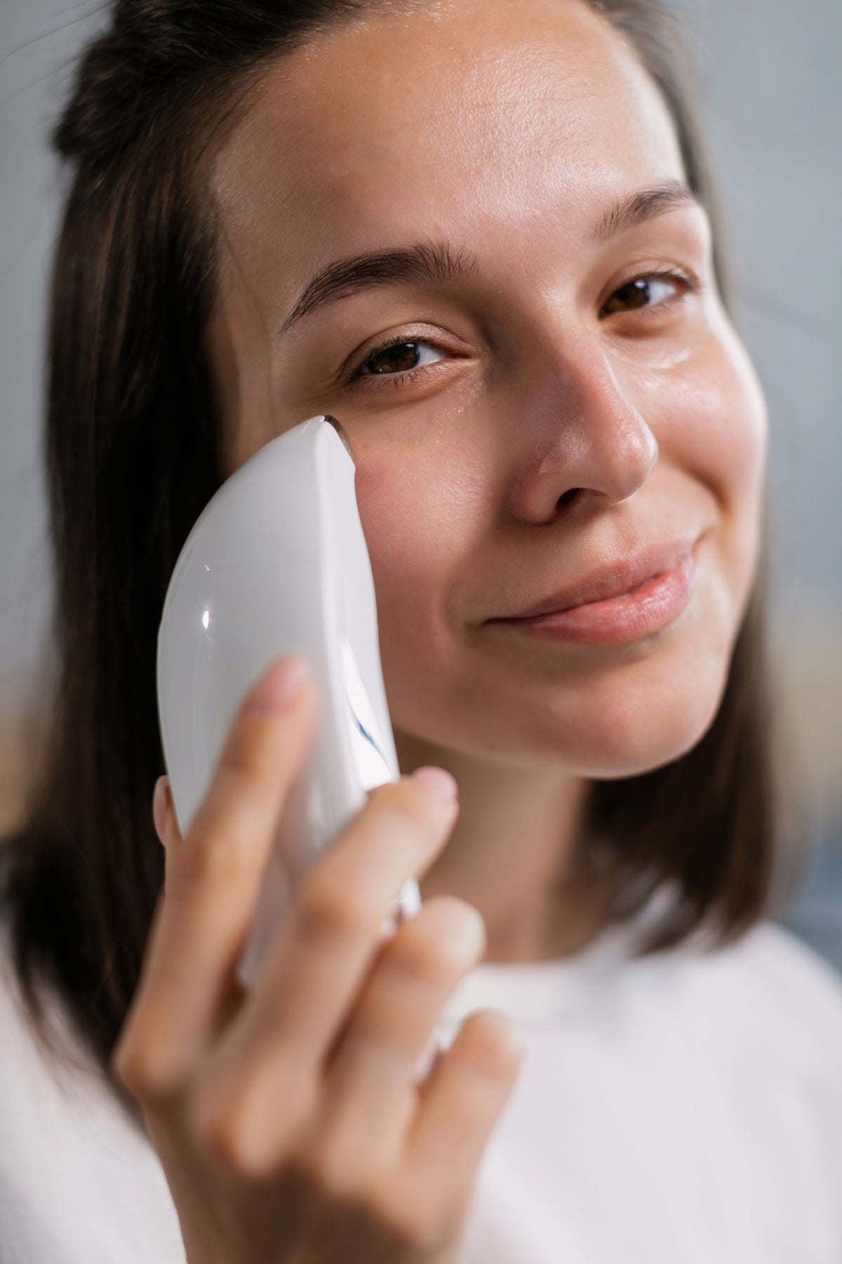 Masajeador facial de microcorriente aplicado sobre el rostro
